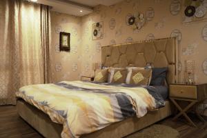 拉合尔Luxury 1 Bedroom Apartment Gold Crest Mall And Residency DHA的壁纸客房内的一间卧室配有一张床