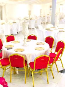 IseyinSILVERZB RESORT的一间设有白色桌子和红色椅子的房间