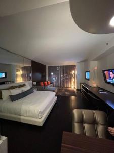 拉斯维加斯Amazing view 18th floor at Palms place Las Vegas的卧室配有一张白色的大床和一张沙发。
