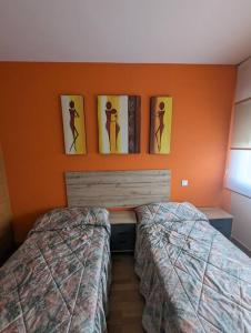 布尔戈斯Piso completo y moderno, Burgos的卧室配有两张床,墙上挂有图片