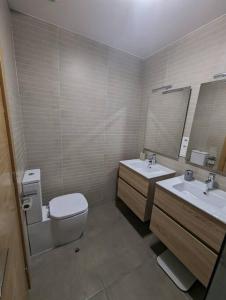 布尔戈斯Piso completo y moderno, Burgos的浴室设有卫生间、2个盥洗盆和镜子