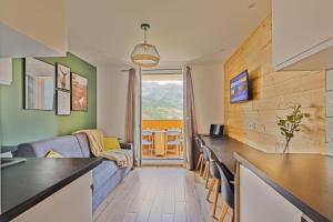 阿洛斯Studio de charme avec vue sur le Val d'Allos, parking et Wifi gratuit的厨房以及带沙发和桌子的客厅。