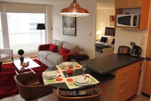 康塞普西翁Concepción Suites的厨房以及带桌子和沙发的客厅。