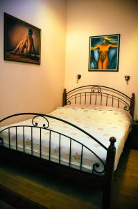 塞格德Sunny Apartman的卧室配有一张墙上有两张照片的床。