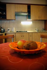 塞格德Sunny Apartman的厨房里的桌子上放着一盘水果