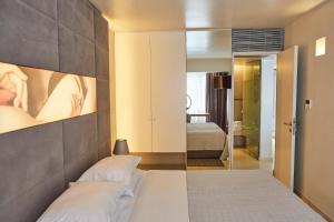 雅典巴西套房精品酒店 的一间卧室配有一张床和镜子