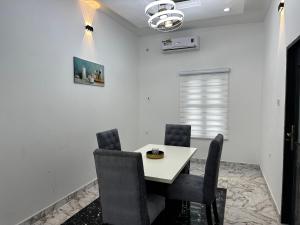 贝宁城KAIR Service Apartments的一间配备有白色桌椅的用餐室