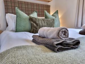 兰鲁斯特Red Tub Cabin Snowdonia的床上有一堆毛巾