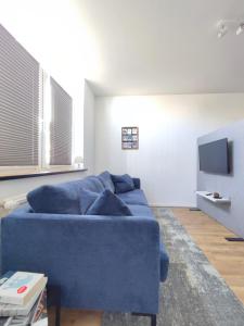 比勒费尔德'BRIGHT 201' Moderne, helle Wohnung in BI Zentrum, 400 m bis Lokschuppen, Smart-TV, WLAN的客厅配有蓝色的沙发和电视