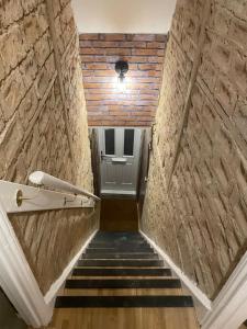 KentStylish & Spacious 2 Storey, 3 Bed Apartment的走廊上设有砖墙楼梯