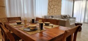 图卢姆Kin Tulum House downtown的客厅里一张木桌,上面有杯子和盘子