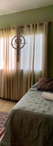 布卢梅瑙Hostel Portal da Montanha的一间卧室配有床和带窗帘的窗户