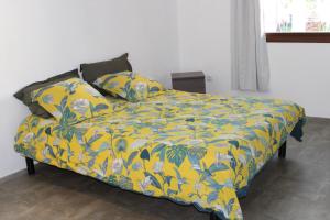 Rémire-CampVilla Émeraude - Piscine privée sans vis à vis的一张带黄色毯子和枕头的床
