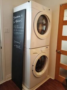 萨格奈Logement avec stationnement tennis et piscine的标牌的房间里的洗衣机和烘干机