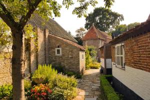 巴勒哈姆斯泰德Countryside Bliss: Historic Cottage by the Sea的老砖楼里一条有树的小巷