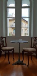 洛夫兰Apartment Dhalia的一个带两扇窗户的房间,配有一张桌子和两把椅子