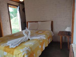 圣安东尼奥-杜皮尼亚尔Solar dos Pinhais的一间卧室配有带毛巾的床