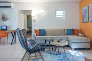 克拉伦代克Diver's Paradise Bonaire的客厅配有沙发、椅子和桌子