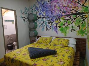 Carmen de ViboralHostal Macondo Inn的一间卧室配有一张壁画床
