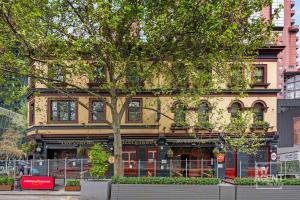 墨尔本Melbourne Bourke Street Bliss的前面有树的黄色建筑