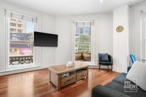 墨尔本Melbourne Bourke Street Bliss的一间带电视和沙发的客厅