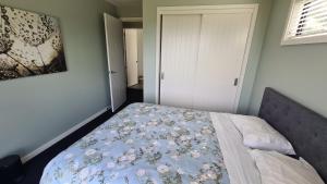 纳皮尔Room With A view的一间卧室配有一张带花卉毯子的床