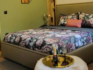 波罗维茨Pinewood ANG luxurious apartment A32的一张带桌子的床,上面有一瓶和眼镜