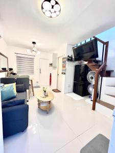 巴科洛德Nyssa Crib 2BR Whole Townhouse Camella Bacolod South的客厅配有蓝色的沙发和电视
