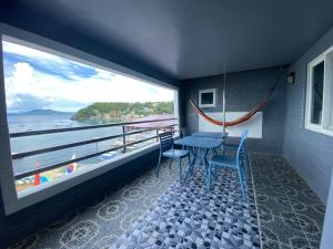波尔多·格尼拉Anak Jay Ang的阳台配有桌椅,享有海景。