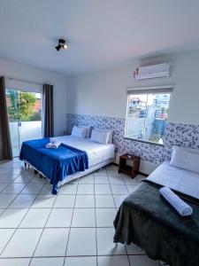 伊塔帕里卡岛维拉克鲁兹Pousada Jardins - Mar Grande的一间卧室设有两张床和窗户。