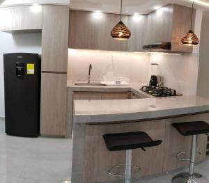 内瓦Encantador Apto Con Aire的厨房配有水槽、炉灶和冰箱