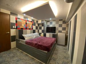 波尔多·格尼拉Anak Jay Ang的一间卧室配有一张床和一台电视。