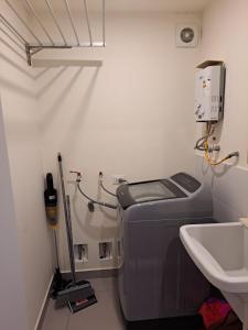 利马Departamento Exclusivo clase A的小型浴室设有洗衣机和水槽。