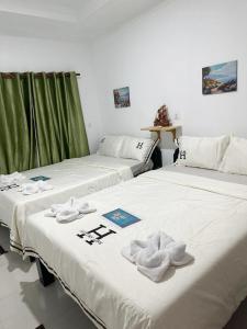 瓜隆岛Green Ocean Lodge的两张睡床彼此相邻,位于一个房间里