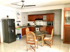 阿卡普尔科Casa Bocoyna的厨房配有桌椅和冰箱。