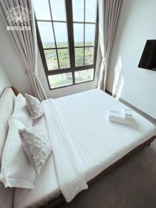 Phước LýWhite Lotus Hotel - Swanbay的卧室配有一张大白色床和窗户