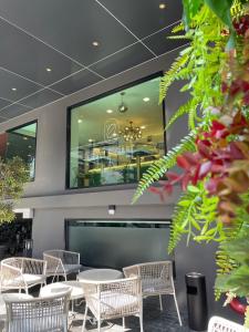 曼谷City Park Hotel Bangkok Pratunam by PCL的餐厅设有桌椅和大窗户。