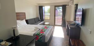 南迪Vualiku Hotel & Apartments的酒店客房,配有床和电视