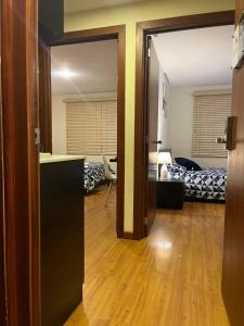 昆卡Departamento de 2 Habitaciones, full amoblada con todo para que disfrutes de tu Estancia的一间设有门的房间,可通往带卧室的房间