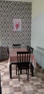 瓜拉弄宾Homestay D'Hiburan Kuala Rompin的餐桌、两把椅子、一张桌子和一面墙