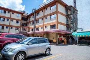内罗毕Jupiter Guest Resort - Langata的停在大楼前的银色汽车