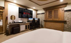 首尔Doksan 3S Hotel的一间卧室配有一张床、一张书桌和一台电视。