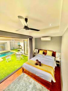 乔木提恩海滩Pattaya Jomtien Private Luxury Pool Villa 芭堤雅中天豪华私家泳池别墅的一间带大床的卧室和一个游泳池