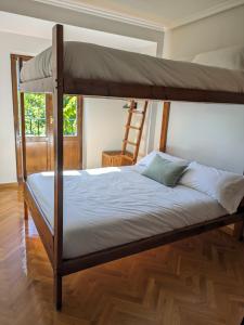 毕斯卡斯Piso Grande La Viña的一间卧室配有带梯子的双层床
