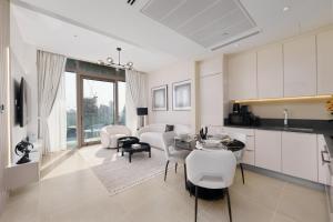 迪拜Maison Privee - Modern Luxury Apt with Spectacular Dubai Marina Vws的厨房以及带桌椅的起居室。