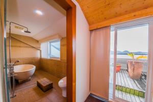 垦丁大街四季峇里时尙旅店的带浴缸、卫生间和窗户的浴室