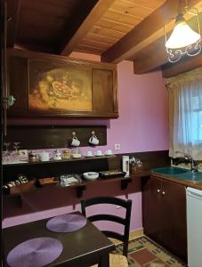 塞尼梅西奇卡罗Ξενώνας Λίκνο的厨房设有粉红色的墙壁、桌子和水槽