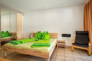 德根豪塞尔塔尔布赫曼度假公寓的一间卧室配有一张带绿色床单的床和一把椅子