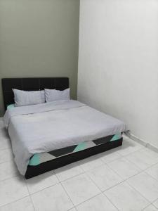 乌鲁地南June's Homestay@ Puteri Wangsa near Aeon & IKEA的一间卧室配有一张带黑色床头板的床