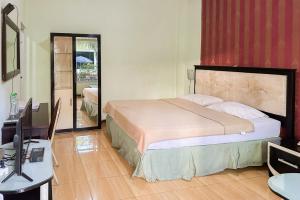 Global Inn Syariah Mitra RedDoorz near Juanda T1 Airport的一间卧室配有一张床、一张书桌和一台电视